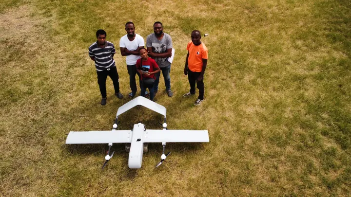 Aerial view of the Altair team beside a VTOL aircraft
