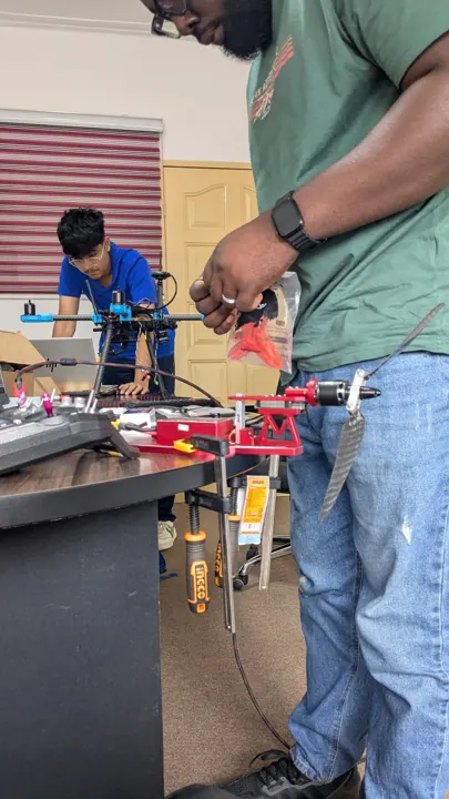 Technician wiring and servicing a multirotor drone in the workshop